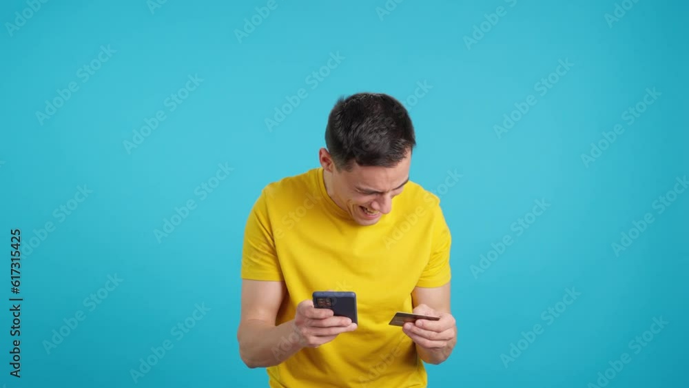 Man shopping compulsively with credit card and mobile phone Man shopping compulsively with credit card and mobile phone