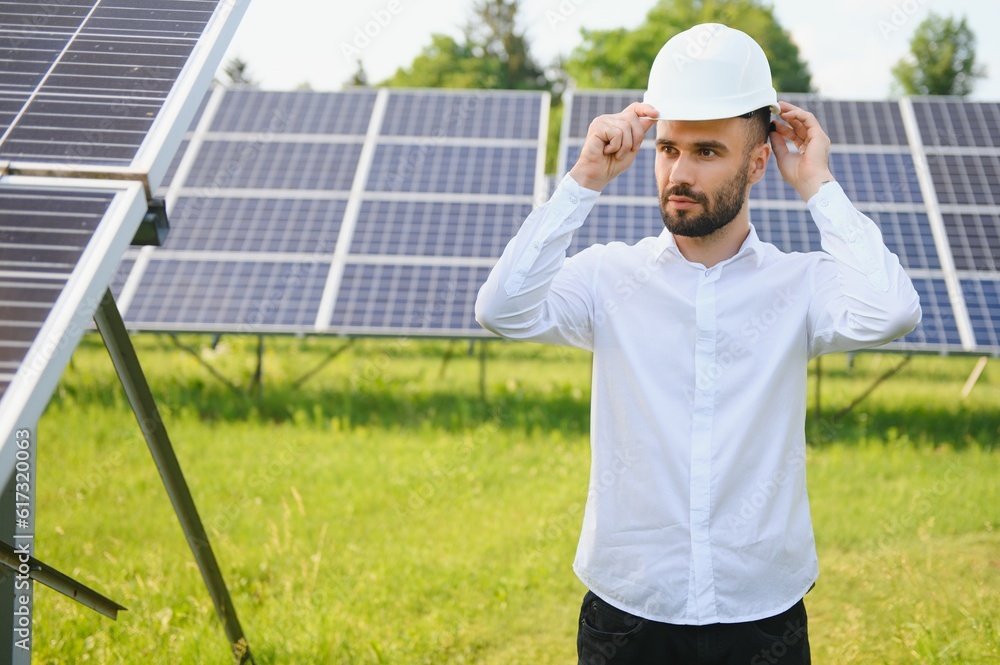 Naklejka premium Young architect standing by solar panels