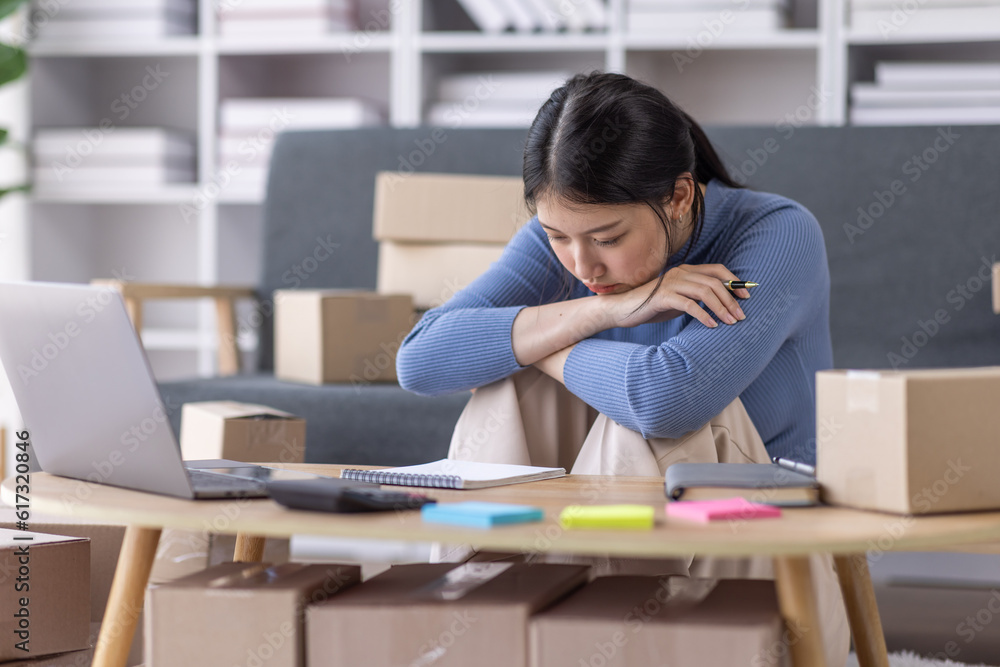 Young asian woman ecommerce SME business stressed leaning on package at home office, stressed headache Startup small business entrepreneur asian woman work package post shipping box delivery parcel Young asian woman ecommerce SME business stressed leaning on package at home office, stressed headache Startup small business entrepreneur asian woman work package post shipping box delivery parcel