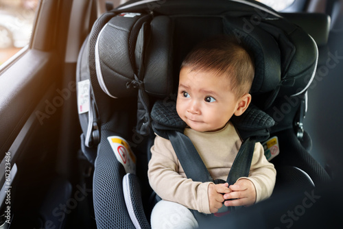 Картината върху платно happy infant baby sitting in car seat and looking out of window, safety chair tr