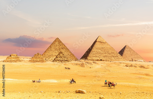 Obraz na płótnie Pyramids of Egypt at sunset with tourists nearby, Giza desert, Cairo w salonie