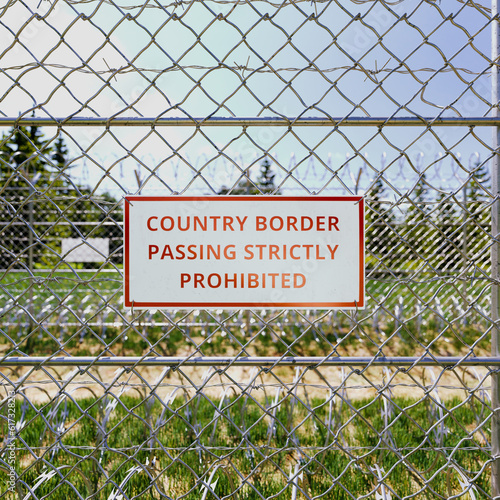 Country border sign. Passing is strictly prohibited. Boundary fence. Migration photo