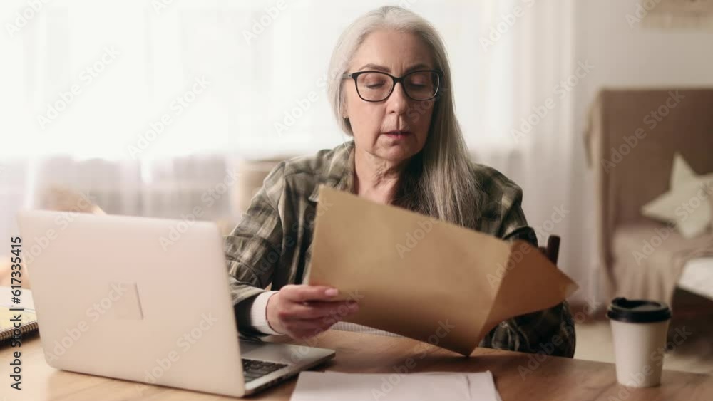 Senior woman with glasses checking mail open envelope and celebrate win success reading great news feel amazed happy reading message mail at home Triumph Lucky Wow concept