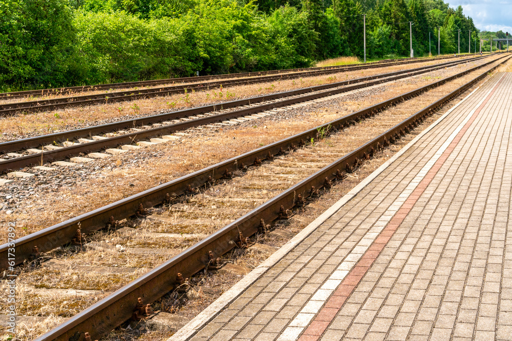 Railway platform with paving stones and empty tracks
