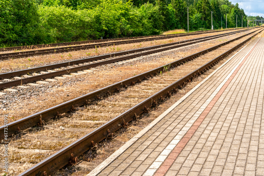 Railway platform with paving stones and empty tracks Railway platform with paving stones and empty tracks