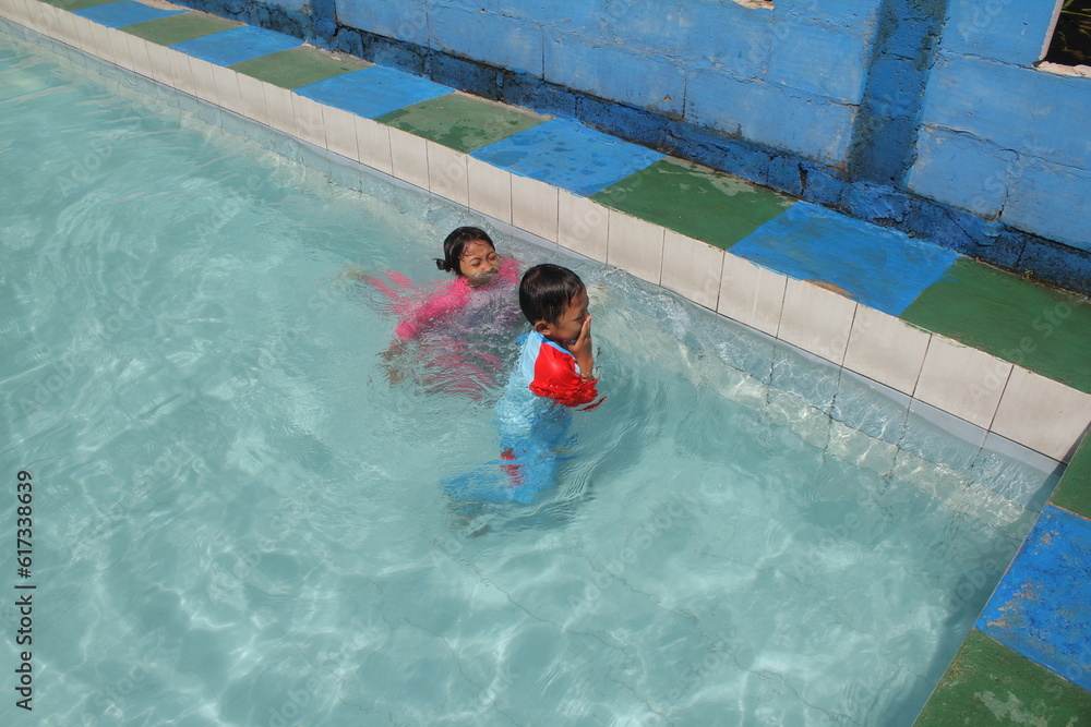 boys and girls practice swimming and playing in water
