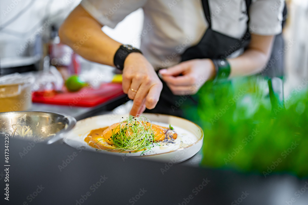 Chef cooking Roasted salmon steak with pumpkin cream on restaurant kitchen