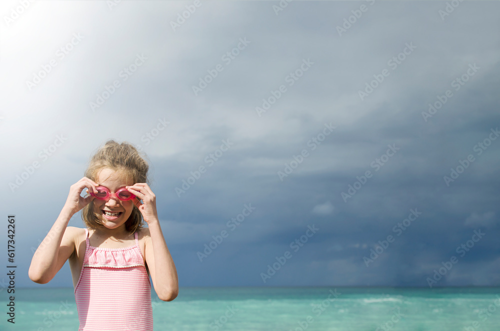 Girl on the beach wearing goggles for swimming Girl on the beach wearing goggles for swimming