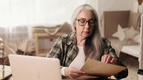 Worried gray haired senior woman open envelope and reading bad negative news feeling disappointed upset at home Defeat Loss Disappointment concept