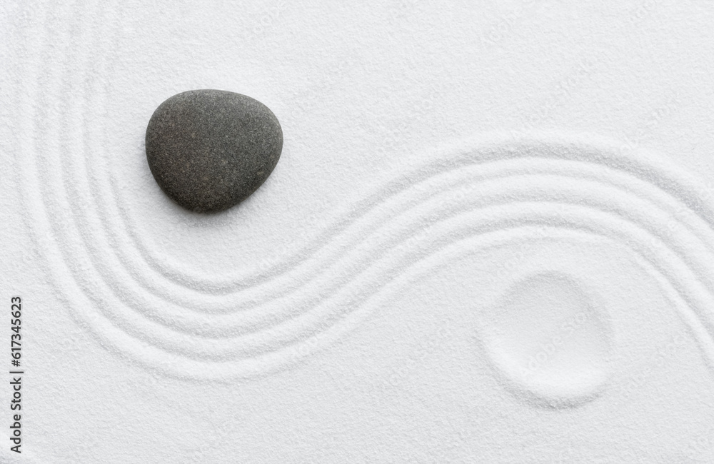 Zen Stone in Japanese garden with grey rock sea stone on white sand