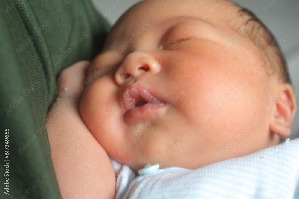 Portrait of a newborn boy who sleeps sweetly and smiles in he sleep in red clothes at a photo shoot of newborns
Portrait of a newborn boy who sleeps sweetly and smiles in he sleep in red clothes at a photo shoot of newborns
