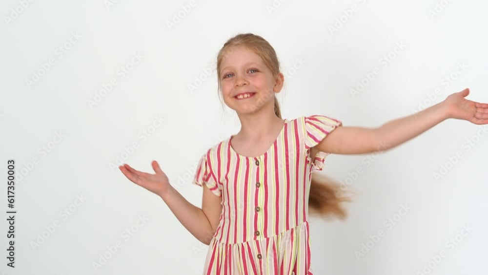 Cheerful, funny girl dancing in a striped dress on an isolated white