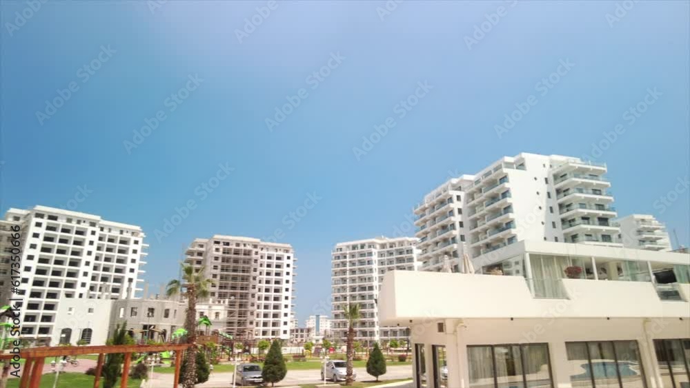 Residential area on a sunny day. Multi-storey buildings against the sky. Place of residence for people, green area in the courtyard relax exterior. Blue sky. Residential area on a sunny day. Multi-storey buildings against the sky. Place of residence for people, green area in the courtyard relax exterior. Blue sky.
