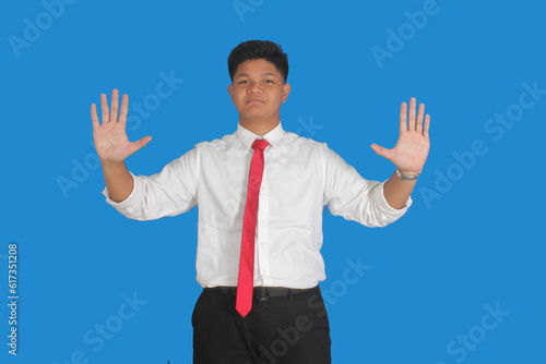 Asian male party cadre in tie pointing up with number five finger smiling confident and happy for election campaign isolated on blue background. 