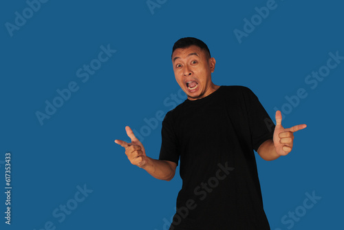 Side view of Adult Asian man smiling happy while pointing finger forward
 photo