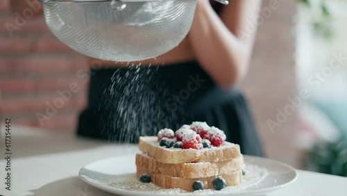 Video of sporty young woman making a delicious and healthy toasts in the kitchen at home. photo