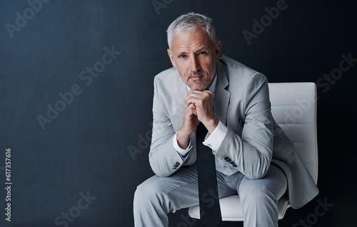 Serious portrait of senior lawyer on chair with confidence, mockup space and dark background in studio. Pride, professional career ceo and executive attorney, mature businessman or law firm boss. photo