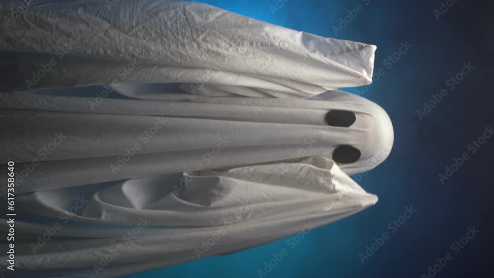 White ghost in smoke on a black background holding a scary head, scary Halloween concept White ghost in smoke on a black background holding a scary head, scary Halloween concept