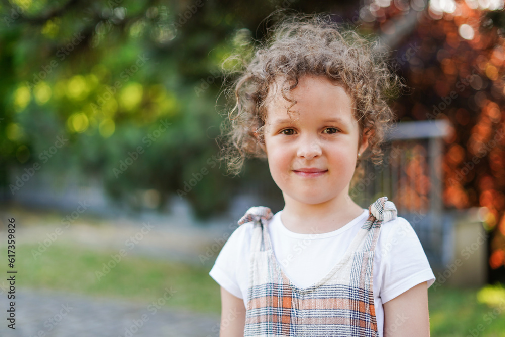 Sweet little girl with curly hair outdoors in the park Sweet little girl with curly hair outdoors in the park