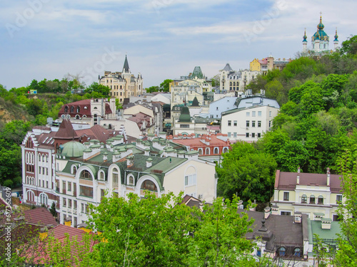 View of an old European city on a green hill, old European architecture with colored roofs, church. The old windows overlook the narrow ancient streets. Ukraine, Kiev, Andriyivsky spusk photo