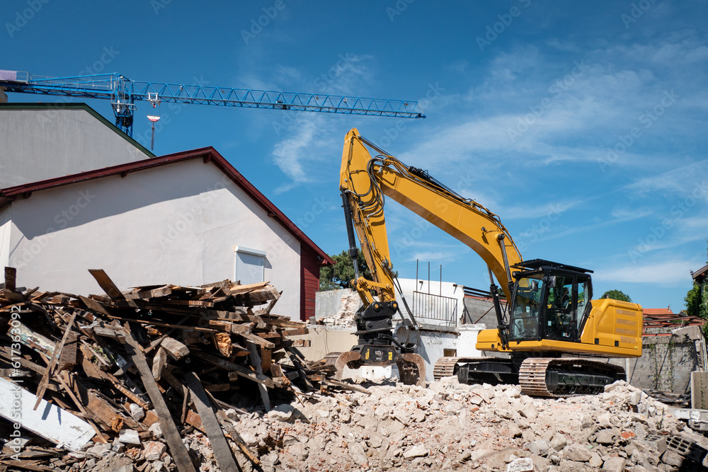 Retroescavadora a demolir uma casa velha para posteriormente se fazer uma nova construção no local Retroescavadora a demolir uma casa velha para posteriormente se fazer uma nova construção no local