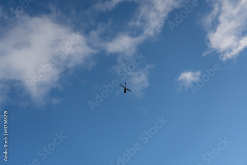 Small reconnaissance helicopter drone in the blue sky.