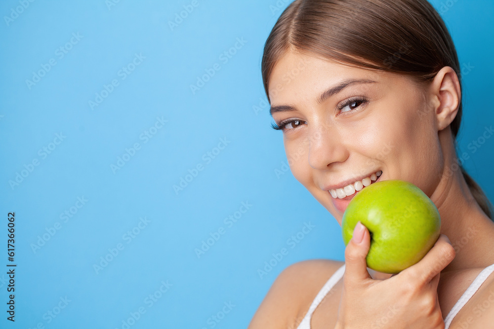Young woman with snow-white smile holding green apple, teethcare. Young woman with snow-white smile holding green apple, teethcare.