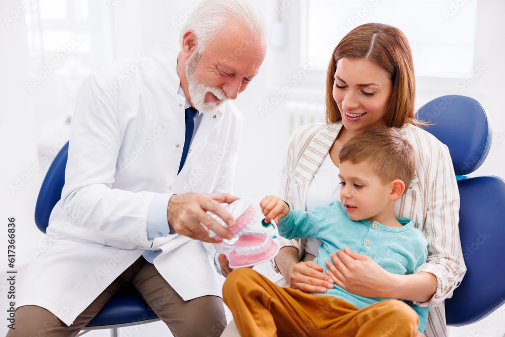 Dentist educating child how to brush teeth properly Dentist educating child how to brush teeth properly