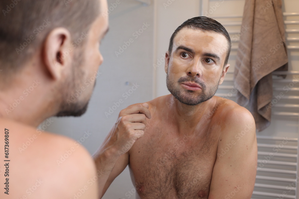 Fototapeta premium Man using a nourishing face mask