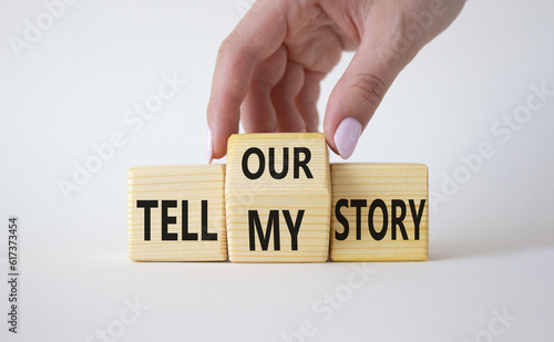 Tell our or my story symbol. Businessman hand turns wooden cubes and changes the words Tell my story to tell our story. Beautiful white background. Business concept. Copy space