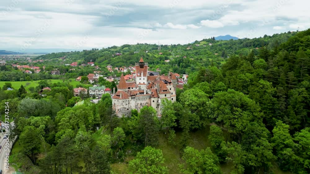 Medieval Bran Castle, aerial drone perspective. Drone rotating around castle In background is the village of Bran. Known as Dracula's Castle, it is visited annually by many foreign tourists. Medieval Bran Castle, aerial drone perspective. Drone rotating around castle In background is the village of Bran. Known as Dracula's Castle, it is visited annually by many foreign tourists.