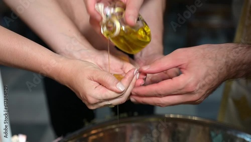 The priest pours oil into his hands