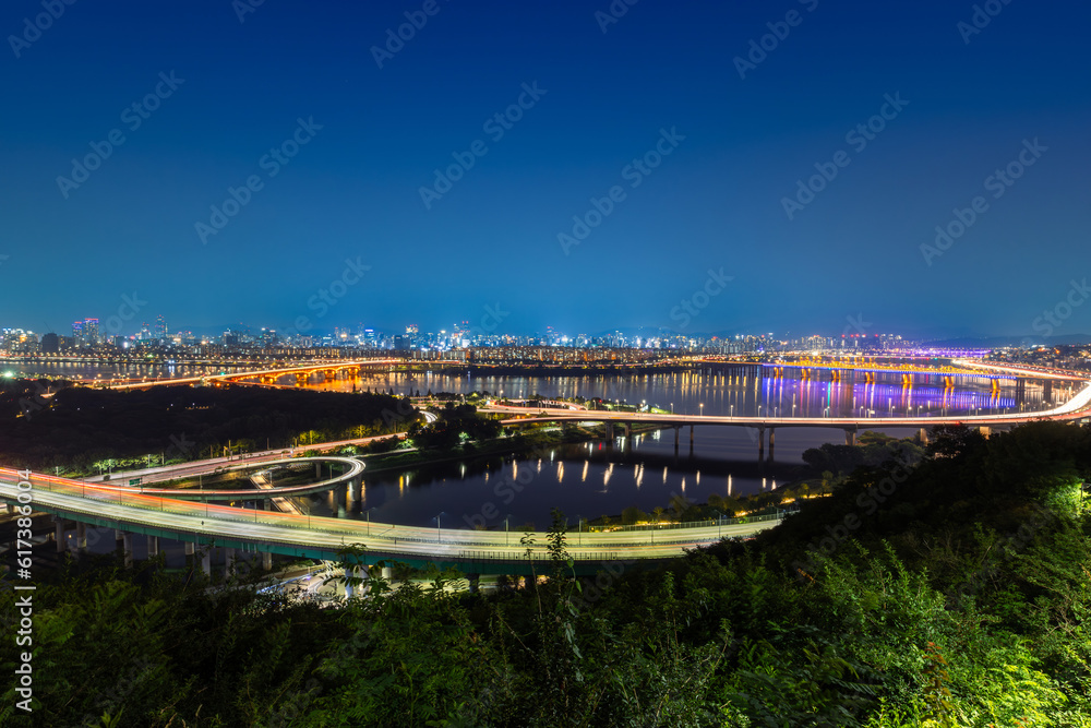 Obraz premium Night cityscape view of Seoul city in South Korea with modern architecture and the light of transportation
