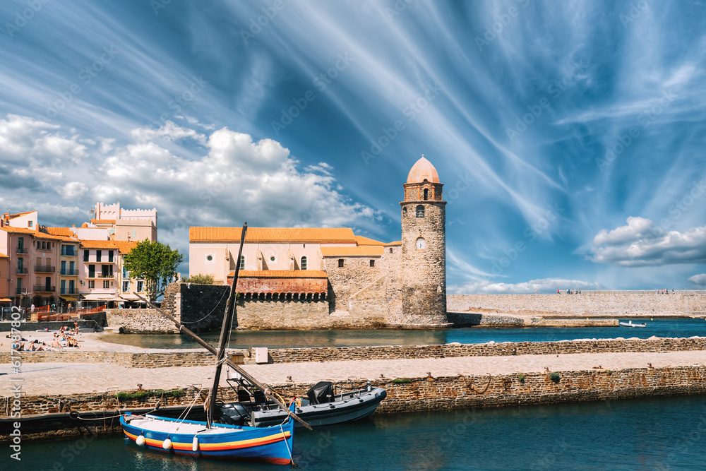Collioure, France. Boats Moored On Berth Near The Church Of Our Lady Of The Angels Across Bay In Sunny Spring Day.