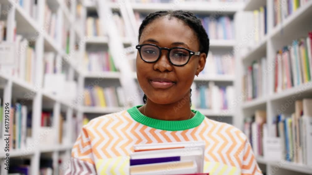 Portrait of african american female student with books in the library Portrait of african american female student with books in the library