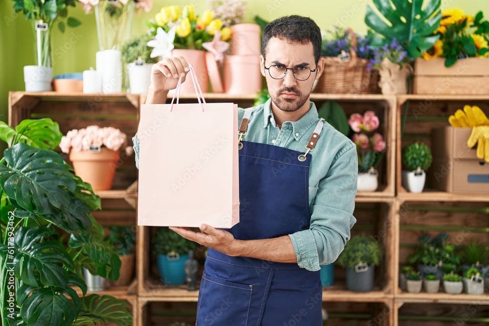 Handsome hispanic man working at florist shop skeptic and nervous, frowning upset because of problem. negative person. Handsome hispanic man working at florist shop skeptic and nervous, frowning upset because of problem. negative person.