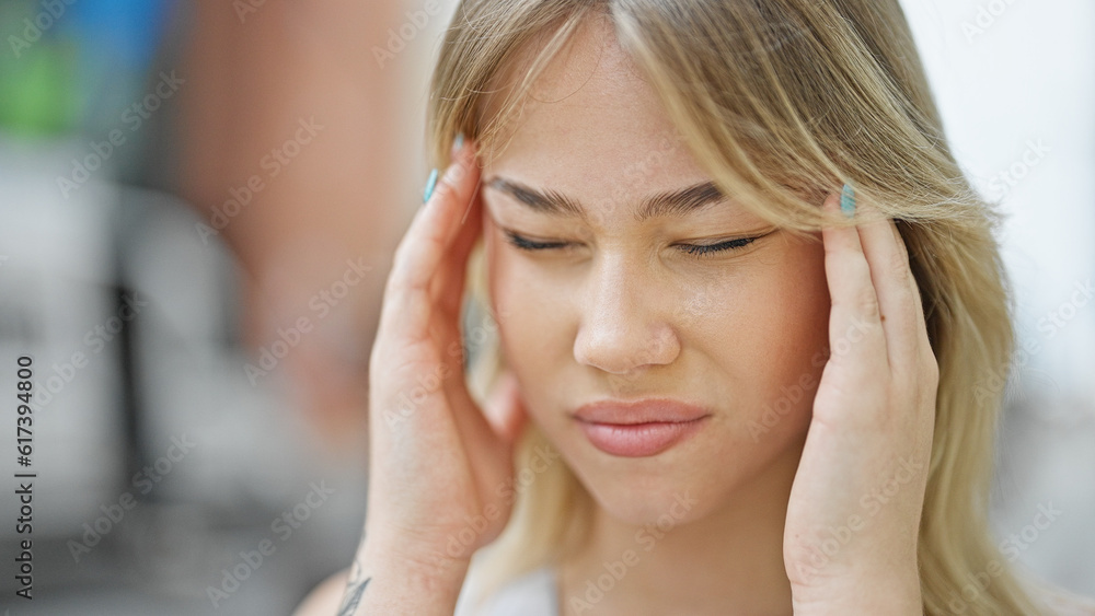 Fototapeta premium Young blonde woman suffering for headache at street