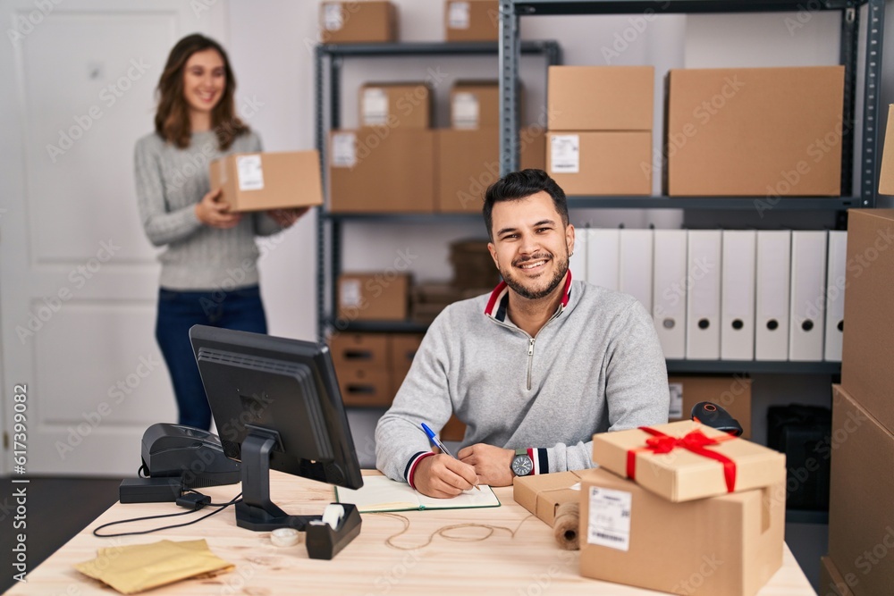 Young hispanic people working at small business ecommerce looking positive and happy standing and smiling with a confident smile showing teeth Young hispanic people working at small business ecommerce looking positive and happy standing and smiling with a confident smile showing teeth