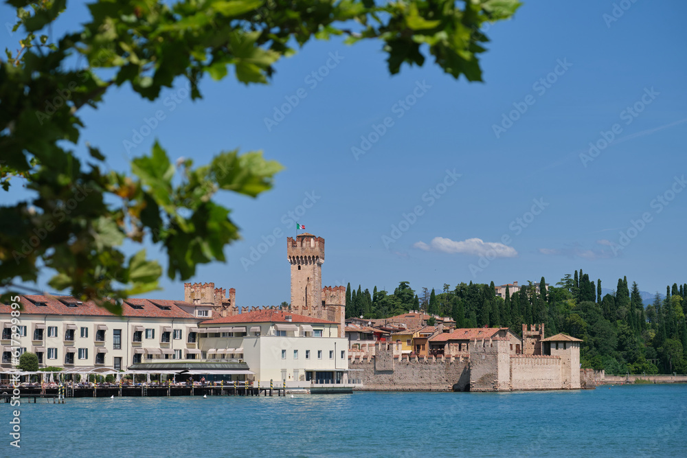 Scaliger Castle, Sirmione on Lake Garda, Italy. Scaliger Castle surrounded by water, sky and trees.