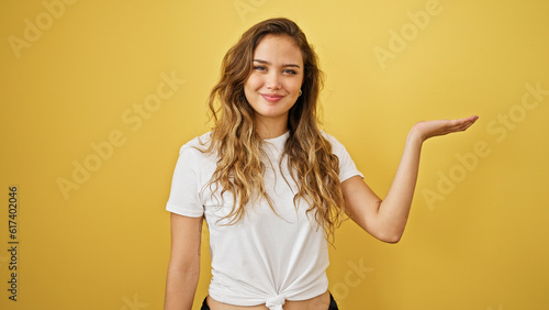 Young beautiful hispanic woman smiling confident presenting over isolated yellow background