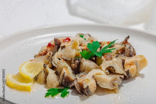 Rapana clam meat with oil, spices and greens. Healthy seafood is rich in omega. Marine decor