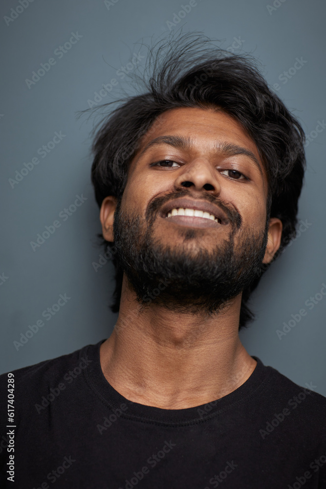 Fototapeta premium A man in a black t-shirt on a gray background with a smile