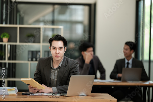 Handsome cheerful asian man executive business man at the workspace office 