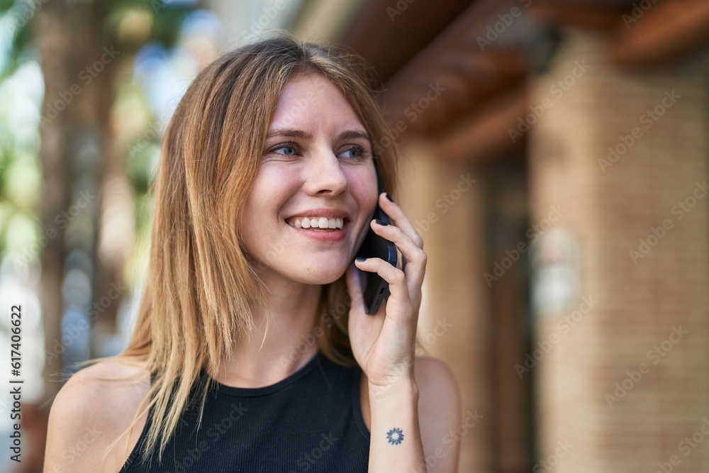 Young blonde woman smiling confident talking on the smartphone at street Young blonde woman smiling confident talking on the smartphone at street