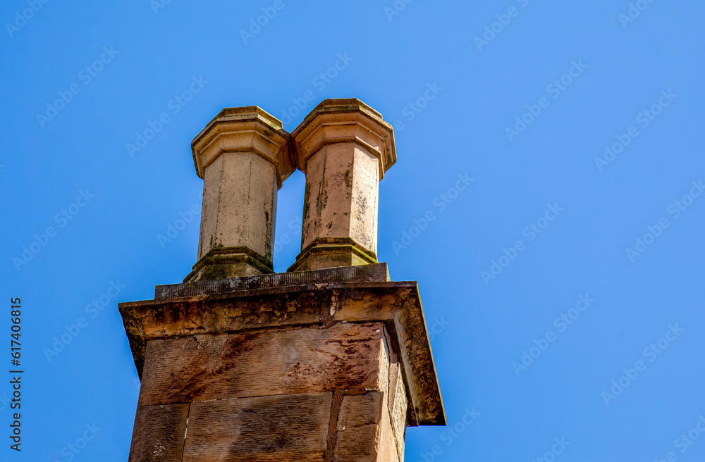 Double chimney stack rising into the bright blue sky