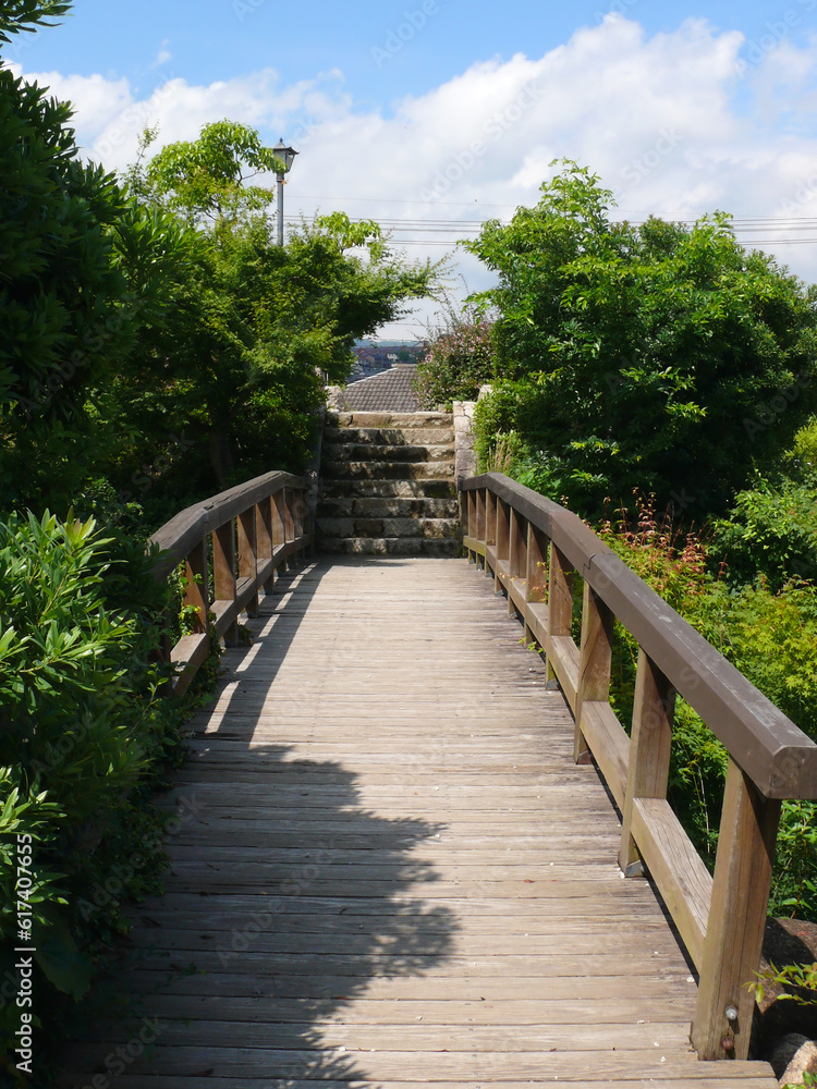 公園の山をつなぐ木の橋とその先の石階段。