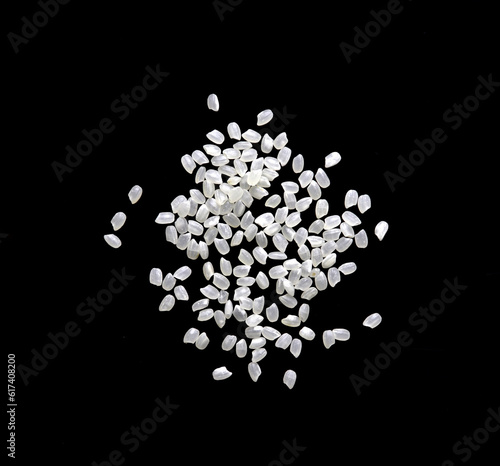 Heaps of uncooked Japanese short grain rice piled together isolated on black background. 