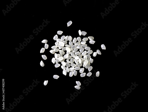 Heaps of uncooked Japanese short grain rice piled together isolated on black background. 
