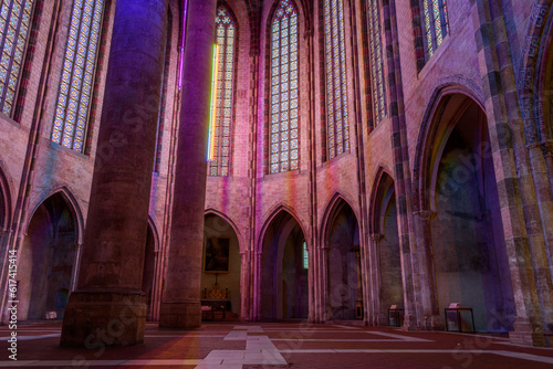 The nave of the church of the Jacobins, a 13th century church, lit up at night, with tall pillars with coloured lights photo
