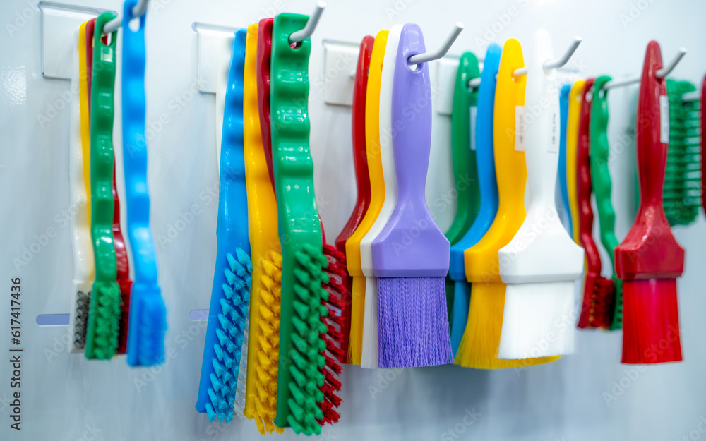 Brushes hang on shelf. Color coded hygiene glazing brushes and detail brushes for food